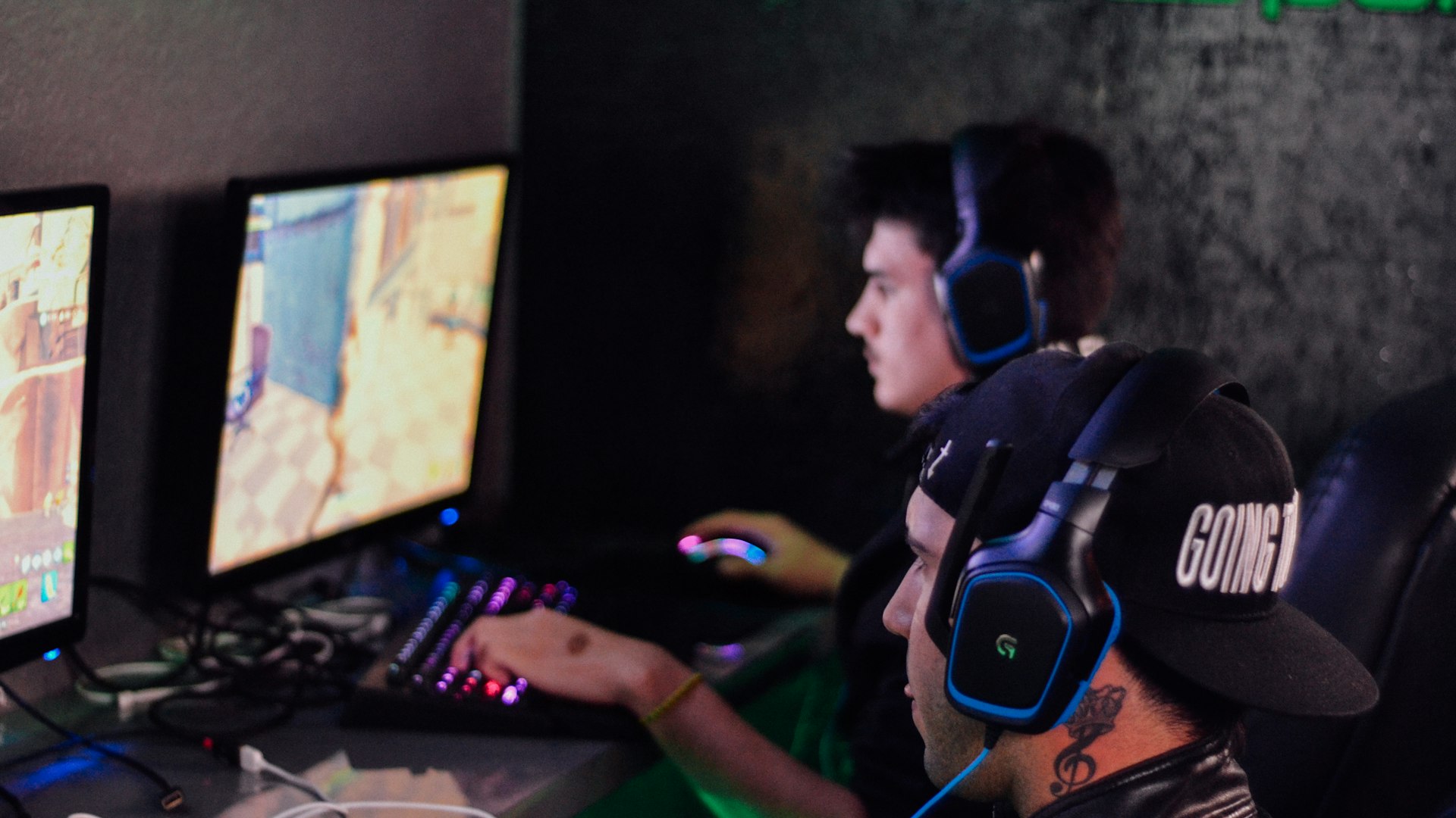 Gaming setup with monitors glowing in a darkened room